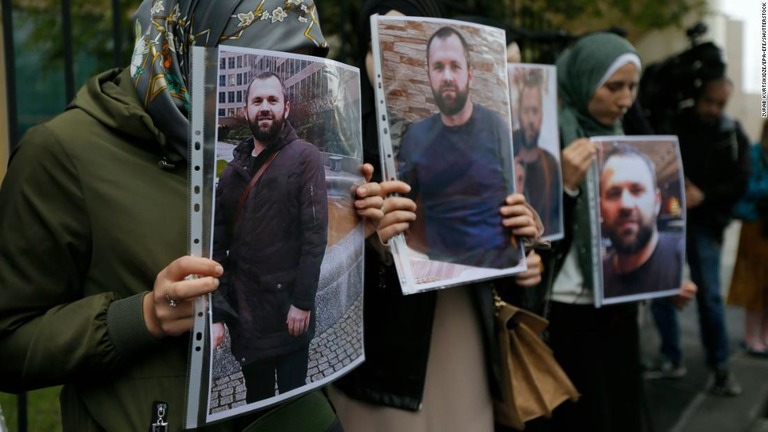 殺害された男性の肖像を持つ人々＝２０１９年９月、ジョージア・トビリシ/Zurab Kurtsikidze/EPA-EFE/Shutterstock